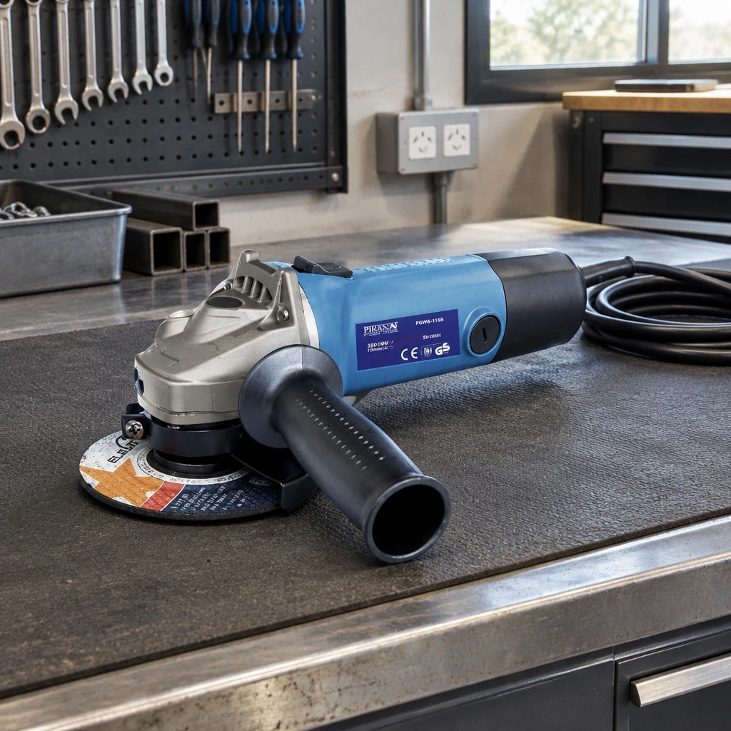 Pirana 115mm corded angle grinder resting disconnected on a workbench in an organised metal fabrication shop