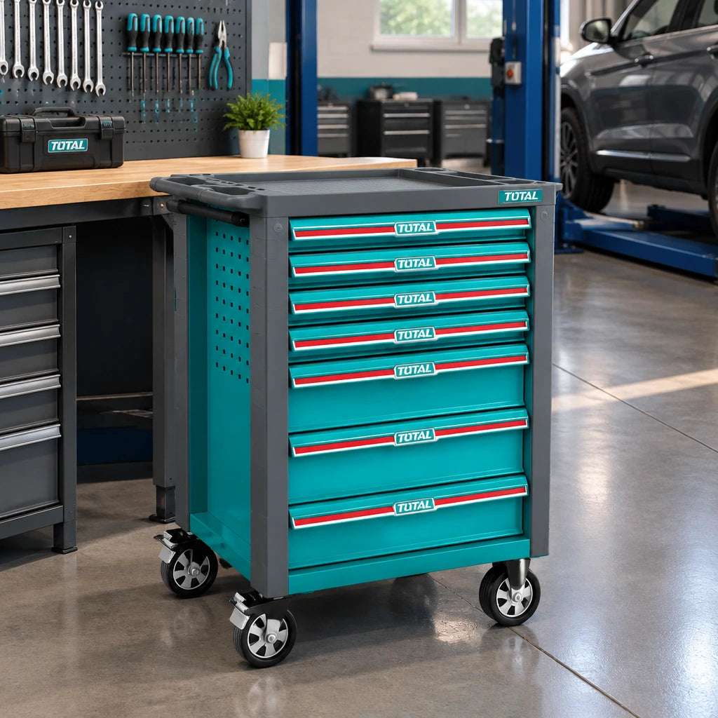 Total seven-drawer rolling tool chest parked beside a workbench in a clean professional automotive workshop.