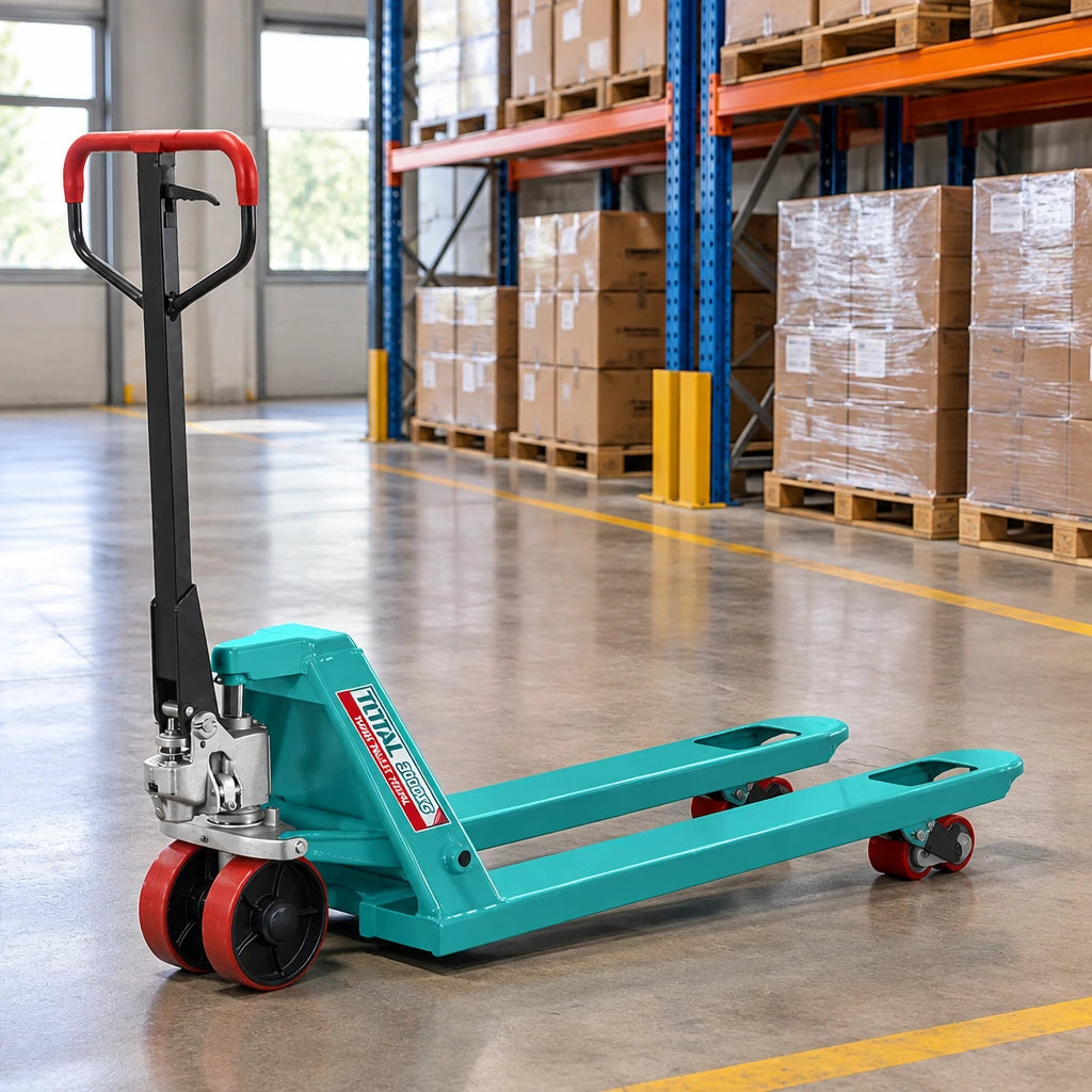Total THT301301 hand pallet truck parked with lowered forks in an organised warehouse staging lane.