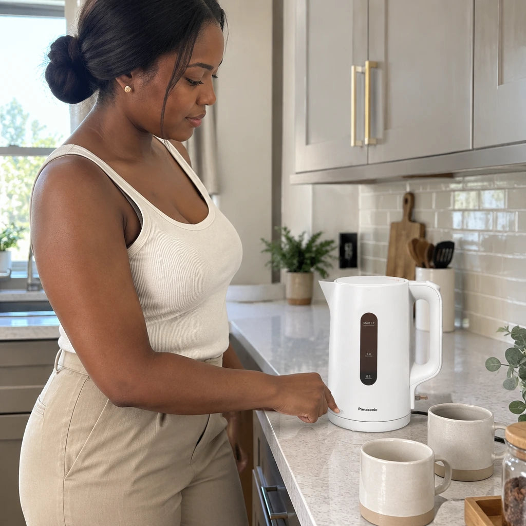African American adult activating a Panasonic K101 white electric kettle to boil water in a refined kitchen