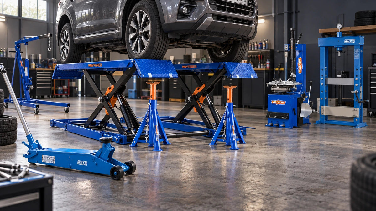 Blue OMCN and Wadfow garage service equipment including a mobile scissor lift, hydraulic trolley jack, jack stands, engine crane, tyre changer and workshop прес