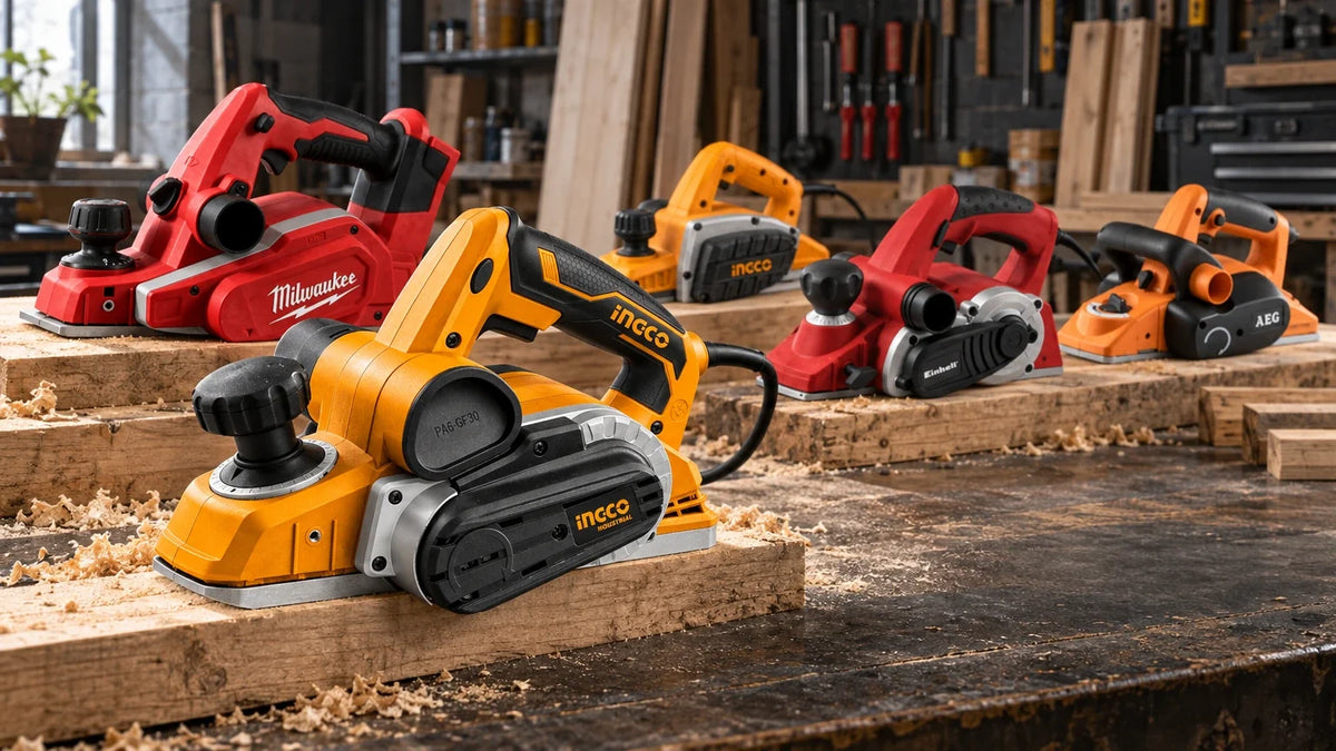 Five branded power planers, including Ingco, Milwaukee, Einhell and AEG models, arranged on timber boards across a professional carpentry workshop bench.