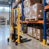Pallet of cartons neatly stored in warehouse racking with an Atlas manual hydraulic stacker parked nearby
