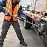African American freight operator using the Atlas 32.5-inch winch bar to tighten a flatbed trailer load winch.