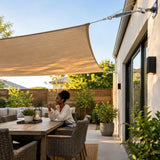Completed courtyard shade structure with taut fabric and Atlas turnbuckle visible at the finished cable connection.