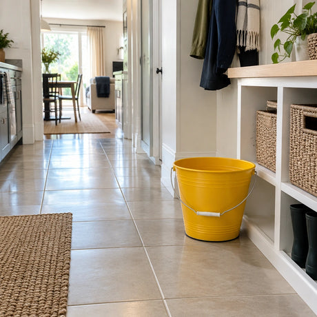 Clean contemporary mudroom with the yellow Greenline 8L utility bucket resting beside storage.