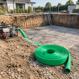 Dry prepared foundation excavation with the green layflat discharge hose resting nearby after dewatering.