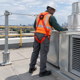 African American facilities technician wearing a red Climax CLI-28-N harness while inspecting rooftop ventilation equipment.