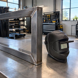 Completed welded steel frame ready for inspection beside a Climax 405-CPA flip-front helmet