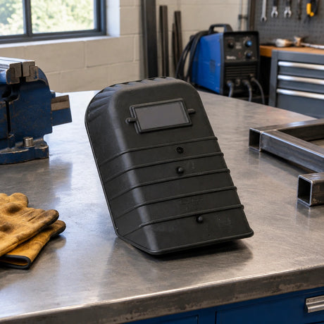 Climax 410-I handheld welding shield resting on a metal fabrication workbench