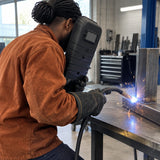 African American welder using a Climax 410-I handheld shield during a short steel-joint weld