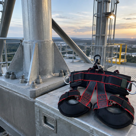 Completed industrial steel support beside a stored Climax Atlas fall-arrest harness after maintenance