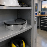 Climax CLI-595-I clear safety glasses resting in a designated PPE cabinet in a clean maintenance room
