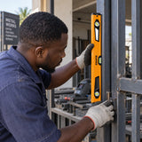 Ghanaian metalworker using a Coofix magnetic spirit level to align a steel gate frame