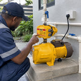Qualified installer commissioning an Ingco 1.5HP automatic household pressure pump at a residential water connection