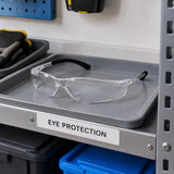 Irona clear safety goggles resting on an organised PPE shelf in a contemporary indoor workshop