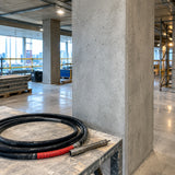Finished reinforced-concrete columns after consolidation with the LAE Exen flexible poker hose resting nearby