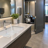 Clean contemporary office washroom with steady basin flow and LuckyPro SMP680C pressure-boosting pump visible in the service cupboard