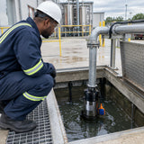 African American wastewater technician monitoring a LuckyPro submersible sewage pump transferring wastewater from an industrial drainage pit