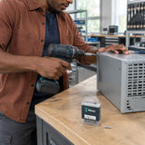 African American production assembler fastening a matching Phillips screw into a metal equipment enclosure with a Wera PH2 bit.