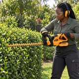 Black gardener using the Coofix hedge trimmer
