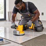 Black installer using the Coofix tile vibrator on a floor tile