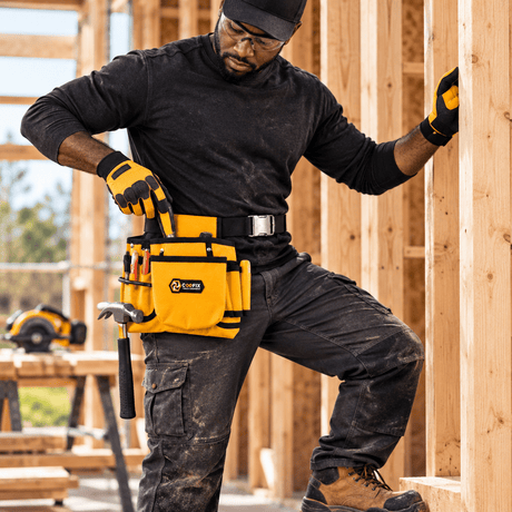 Black professional carpenter wearing and using the Coofix tool belt