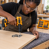 Cabinetmaker using a cordless drill and screwdriver bit to fit a hinge