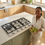 Face-visible lifestyle scene with the Kaiser Avantgarde Pro 90cm stainless-steel five-burner hob
