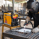Helmeted fabricator using the Ingco plasma cutter on supported sheet steel