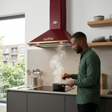 Home cook beneath the Kaiser Empire hood in a modern apartment kitchen