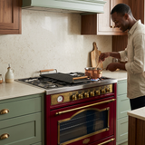 Home cook using the Bordeaux red Kaiser range in a sage kitchen
