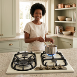 Home cook using the cream Kaiser Empire gas hob in a sunlit kitchen