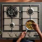 Overhead cooking scene with vegetables in a skillet and a face-hidden cook