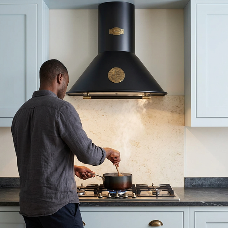 Rear-view cooking scene beneath the black Belle Epoque hood