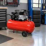 Mirage 2HP 50L belt-driven air compressor parked beside an organised tyre-service area in a clean automotive workshop.