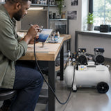 African American airbrush artist using a Mirage MY5002-50 compressor to apply a controlled finish to a prepared panel
