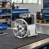 Mirage aluminium compressor replacement pump resting on a clean workshop bench beside compressor rebuild components