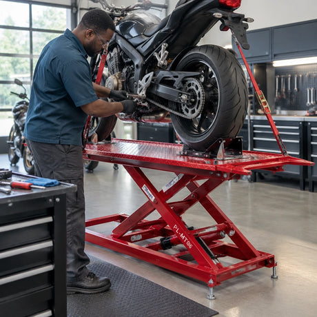 African American motorcycle technician servicing a chain on a raised motorcycle secured on the Mirage PL-MT06 lift.