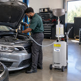 Automotive technician using a Mirage HC-2097 pneumatic waste-oil extractor to remove used engine oil through a vehicle dipstick tube