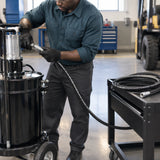 Technician fitting a Mirage replacement grease hose to a mobile grease pump in a clean maintenance bay