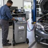 African American automotive technician operating a Mirage AC636 R134a recovery machine during passenger-vehicle air-conditioning service.
