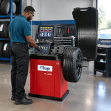 African American tyre technician using the Mirage PL-1828 computerised balancer to measure a mounted vehicle wheel