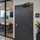 Closed contemporary office entrance with the black Mister hydraulic automatic door closer installed above the door.