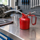 Mister red hand oil can resting on an organised maintenance workshop bench beside mechanical service tools
