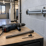 Finished conduit penetration in a commercial plant room with the Mister SDS-Max adapter resting nearby