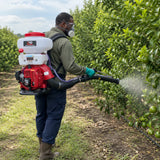 African American orchard worker wearing the NRG gasoline knapsack sprayer while applying an approved liquid treatment to fruit trees