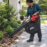 African American homeowner using the NRG electric leaf vacuum to collect dry leaves from a paved terrace