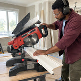 African American trim carpenter using the NRG NMS8120 sliding mitre saw to cut wide moulding