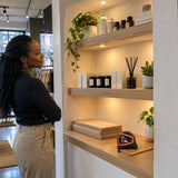 Completed boutique display niche with a fitted timber shelf and NRG auto-lock measuring tape resting nearby.